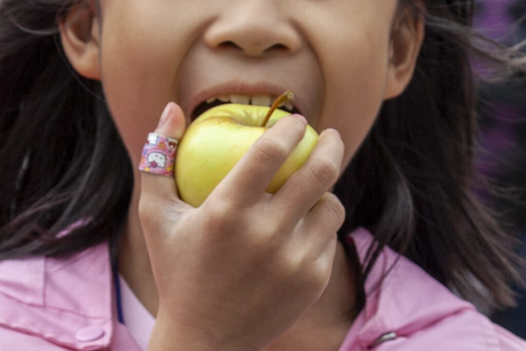 Child eating green apple