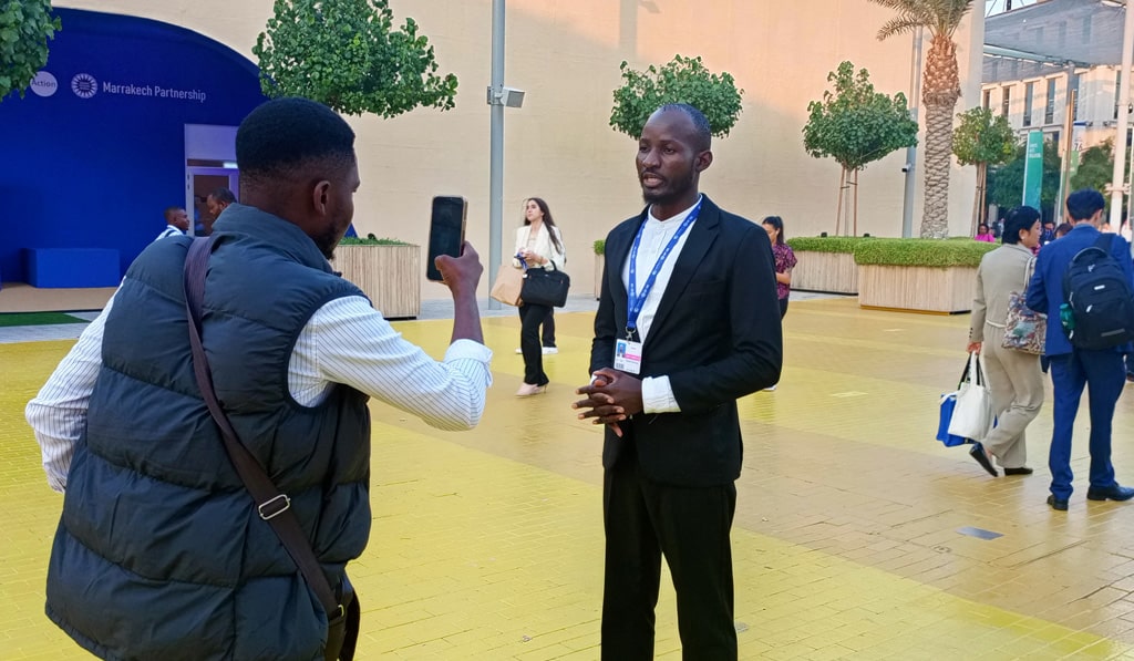 Richard Kachungu stands in the courtyard at COP28 in Dubai